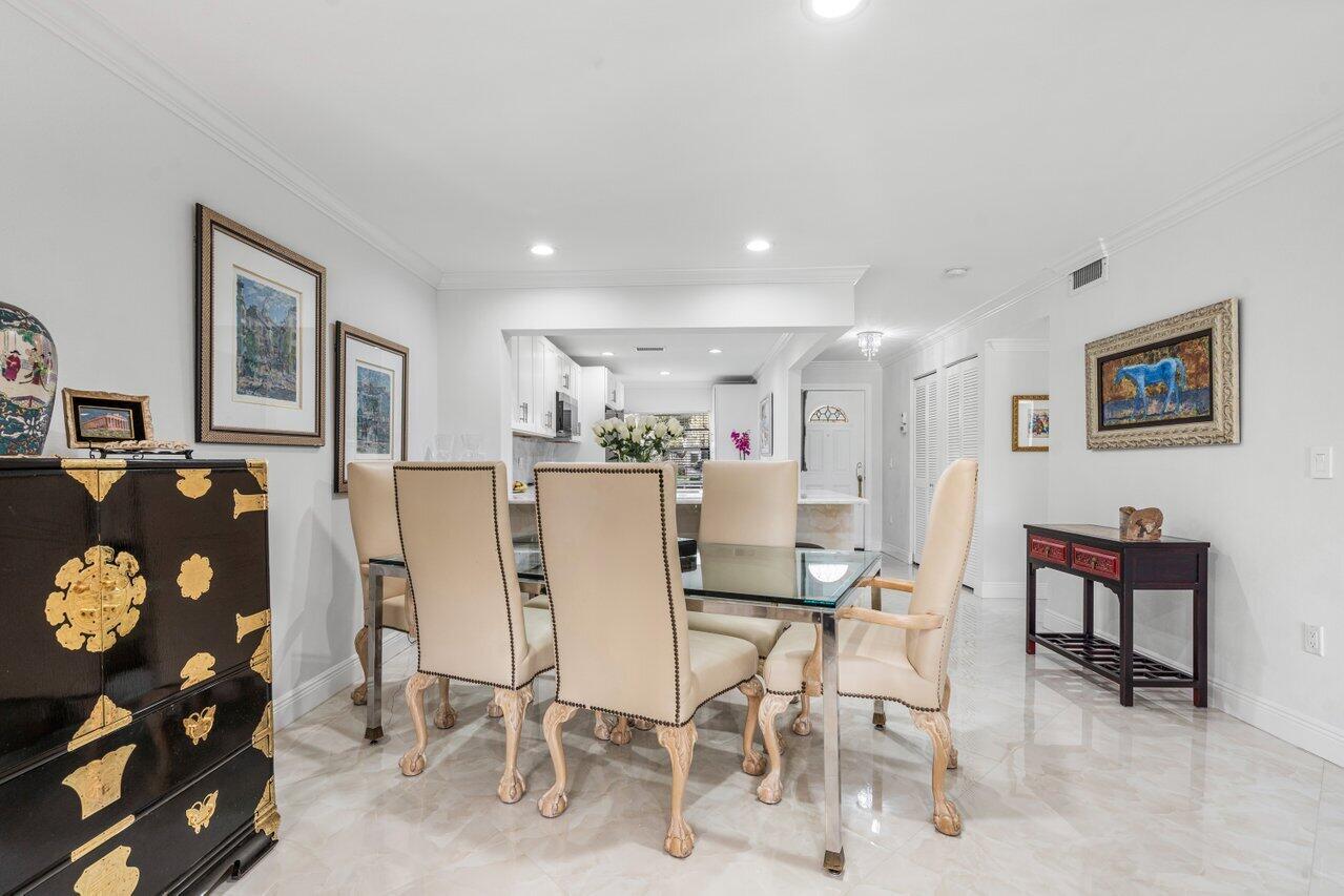 34 Stratford Lane West, Unit C Boynton Beach, FL 33436 - Photo 14 of 38 a living room with furniture a dining table and a refrigerator