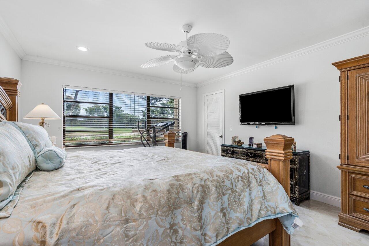 34 Stratford Lane West, Unit C Boynton Beach, FL 33436 - Photo 25 of 38 a bedroom with a large bed and a flat tv screen