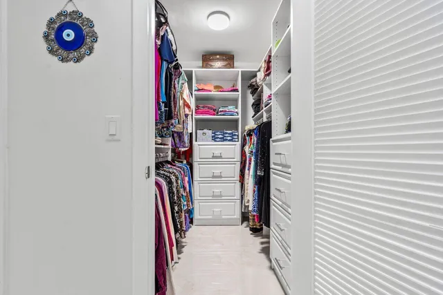 a view of walk in closet with clothes