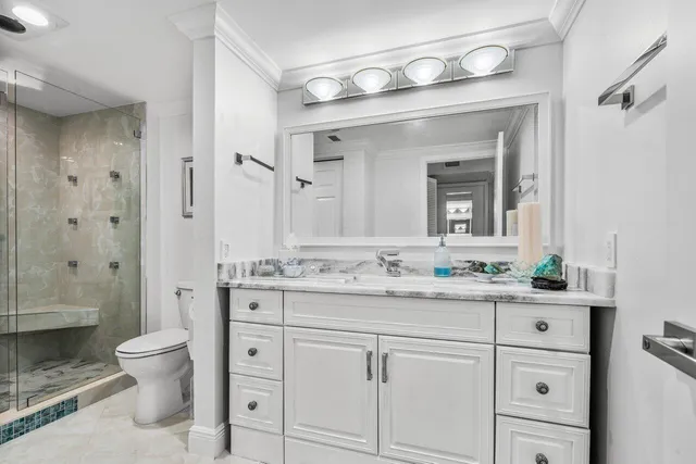 a bathroom with a granite countertop sink mirror and toilet