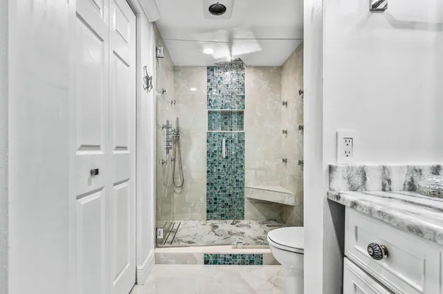 a bathroom with a sink a toilet and shower