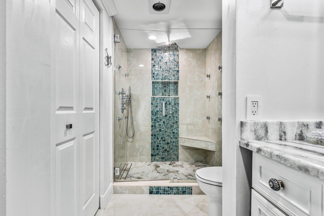 34 Stratford Lane West, Unit C Boynton Beach, FL 33436 - Photo 30 of 38 a bathroom with a sink a toilet and shower