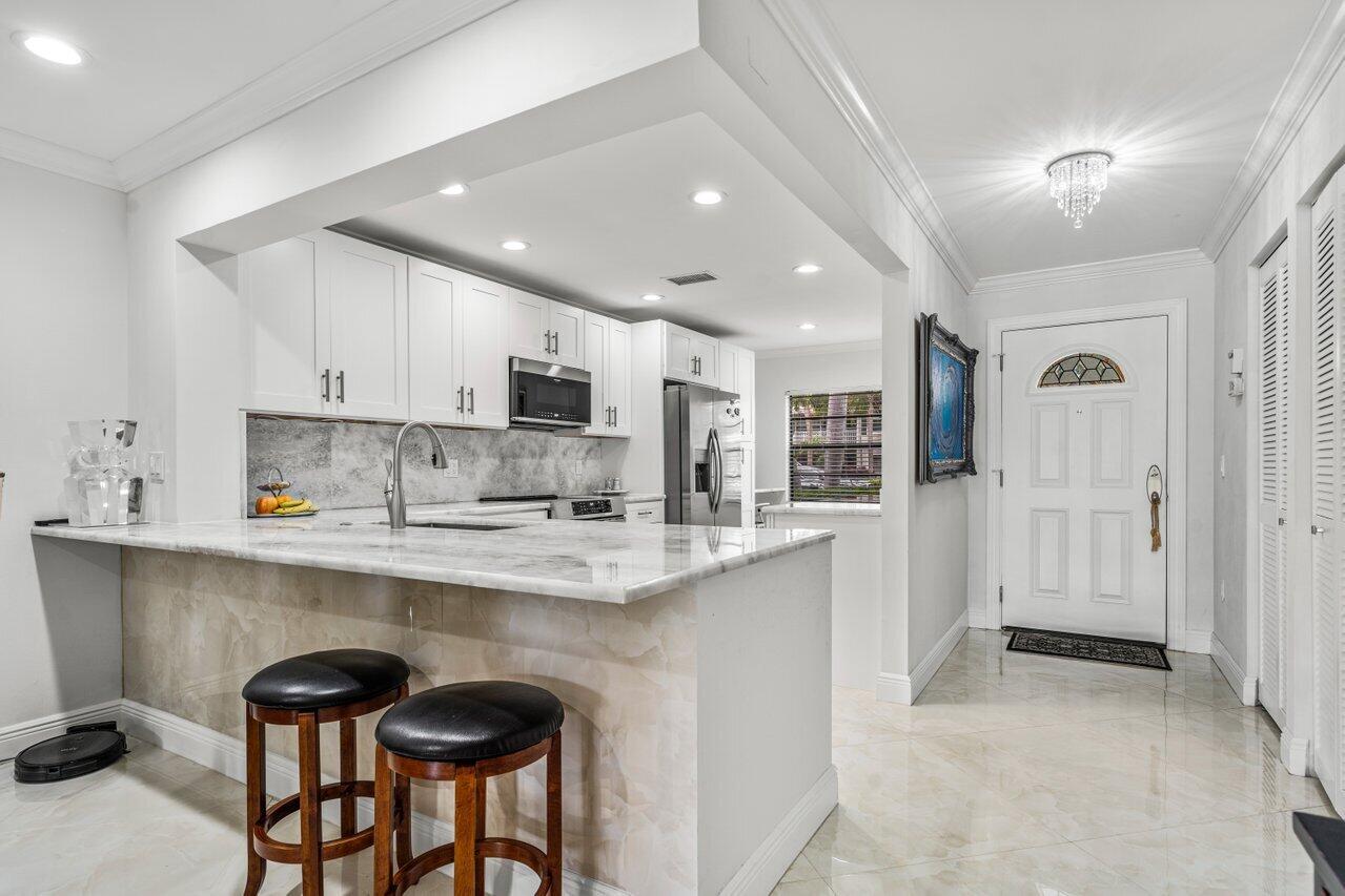 34 Stratford Lane West, Unit C Boynton Beach, FL 33436 - Photo 6 of 38 a kitchen with stainless steel appliances granite countertop a sink and cabinets