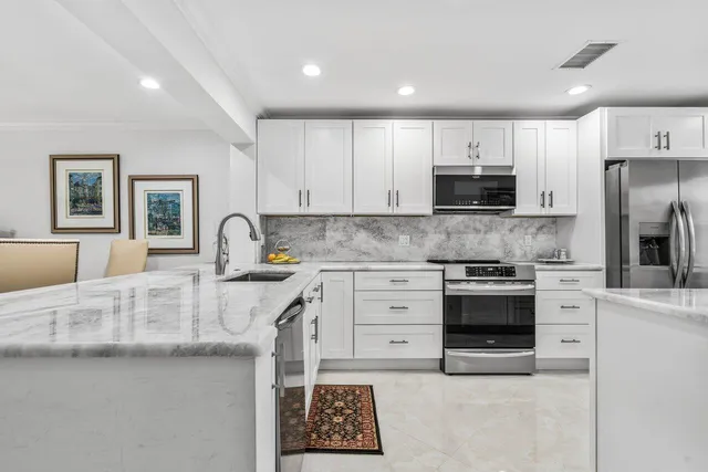 a kitchen with stainless steel appliances granite countertop a stove a sink and a refrigerator