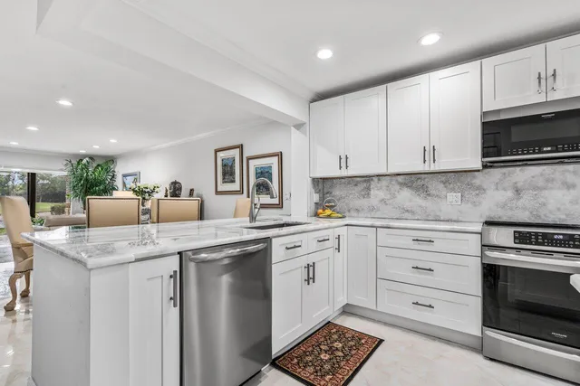 a kitchen with cabinets appliances a sink and a counter top space