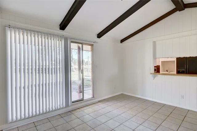 a view of a livingroom with an empty space and a window