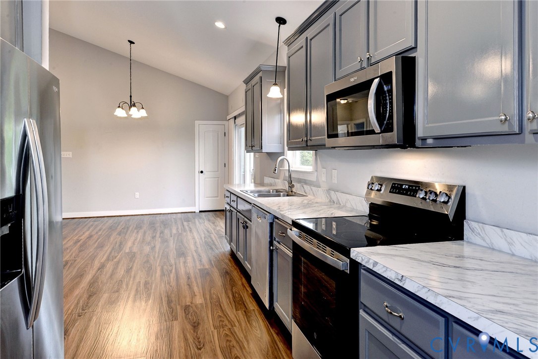 8904 Rock Cedar Road New Kent, VA 23124 - Photo 12 of 37 a kitchen with a sink a microwave a stove and refrigerator
