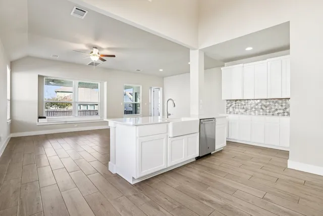 a large white kitchen with a large window a oven and white appliances