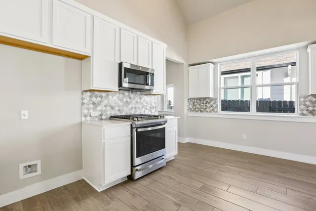 a kitchen with stainless steel appliances a stove microwave and sink