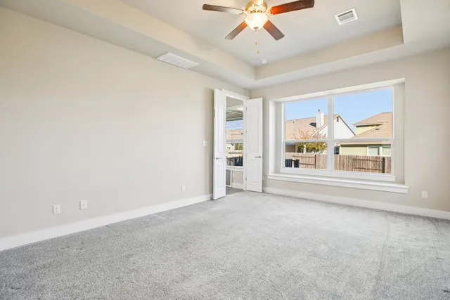an empty room with windows and fan