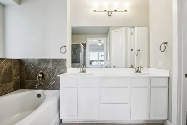 a bathroom with a tub sink and mirror