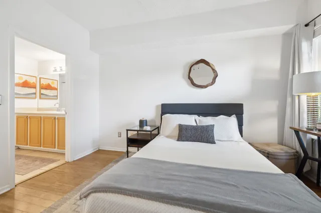 a bedroom with a bed and wooden floor