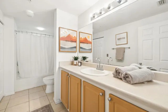 a bathroom with a double vanity sink toilet and a tub