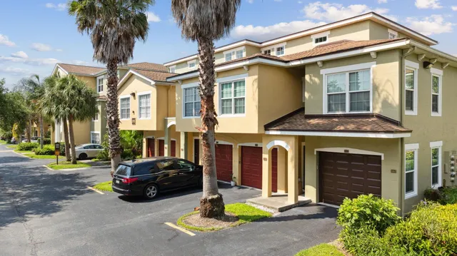 a front view of a house with garden and parking