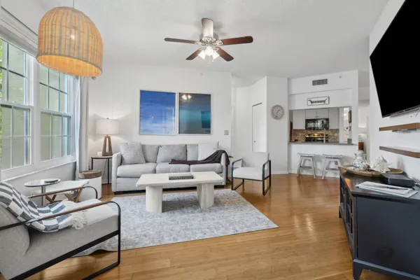 a living room with furniture a flat screen tv and kitchen view