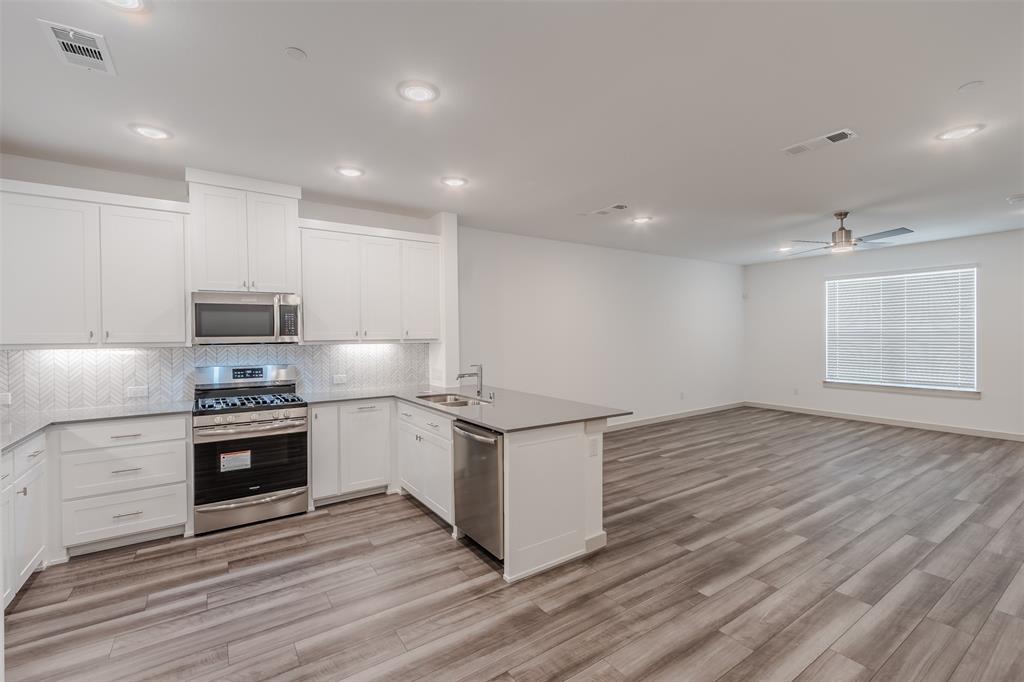 682 Vista Oaks Road Lewisville, TX 75067 - Photo 11 of 38 a kitchen with stainless steel appliances granite countertop a stove and a sink