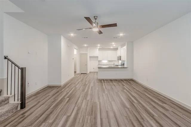 a view of empty room with wooden floor and window