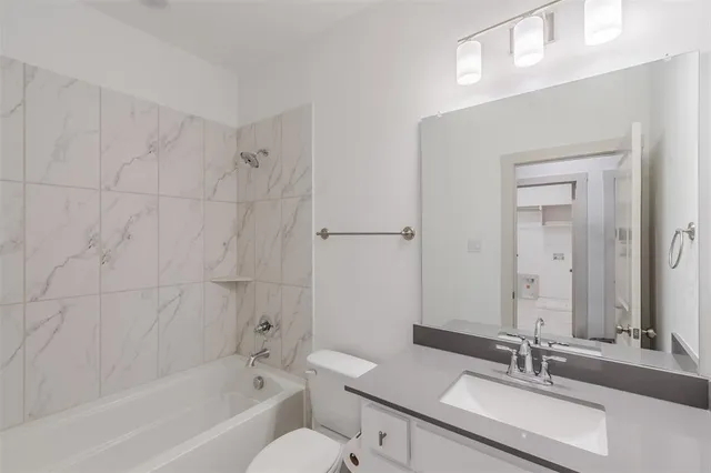 a spacious bathroom with a granite countertop sink a mirror and a shower