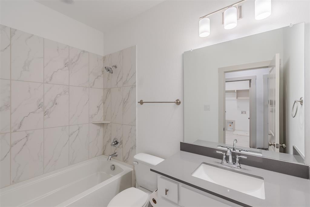 682 Vista Oaks Road Lewisville, TX 75067 - Photo 28 of 38 a bathroom with a bathtub a sink a toilet and a mirror