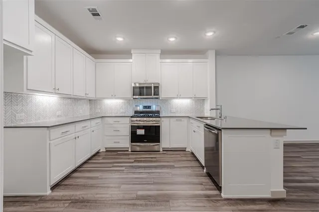 a kitchen with granite countertop a sink and steel appliances