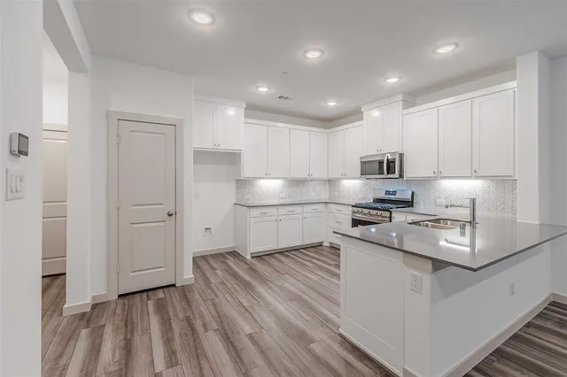 a kitchen with stainless steel appliances granite countertop a sink a stove and a refrigerator