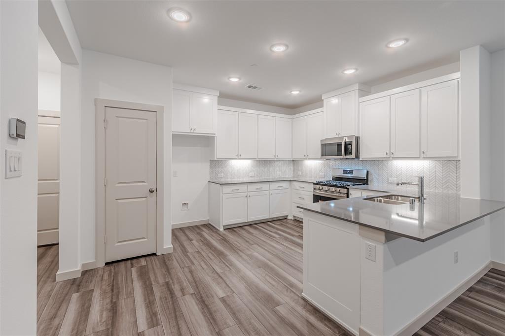 682 Vista Oaks Road Lewisville, TX 75067 - Photo 6 of 38 a kitchen with stainless steel appliances granite countertop a sink a stove and a refrigerator