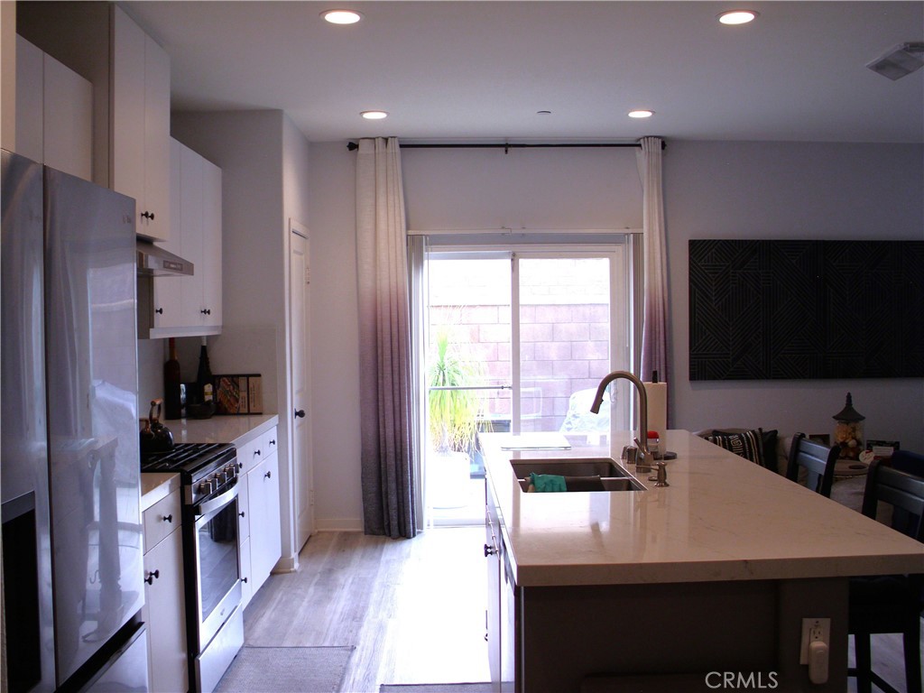 27393 Red Rock Road Moreno Valley, CA 92555 - Photo 16 of 31 a kitchen with kitchen island granite countertop a sink stainless steel appliances and cabinets