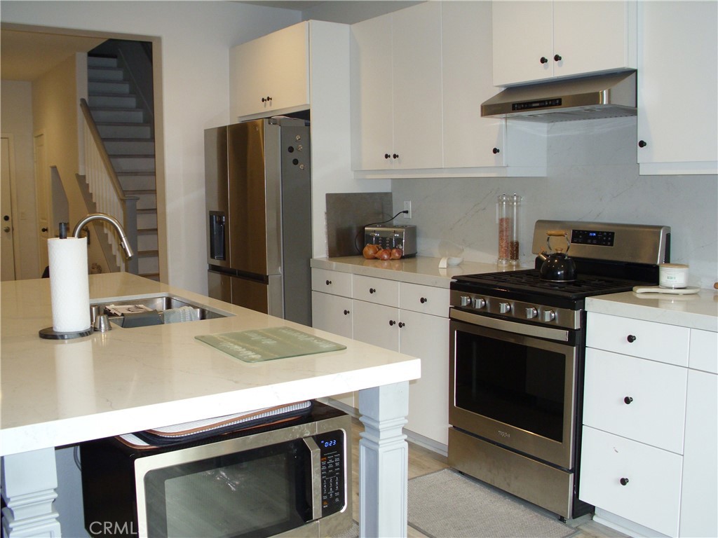27393 Red Rock Road Moreno Valley, CA 92555 - Photo 5 of 31 a kitchen with granite countertop a stove sink and refrigerator