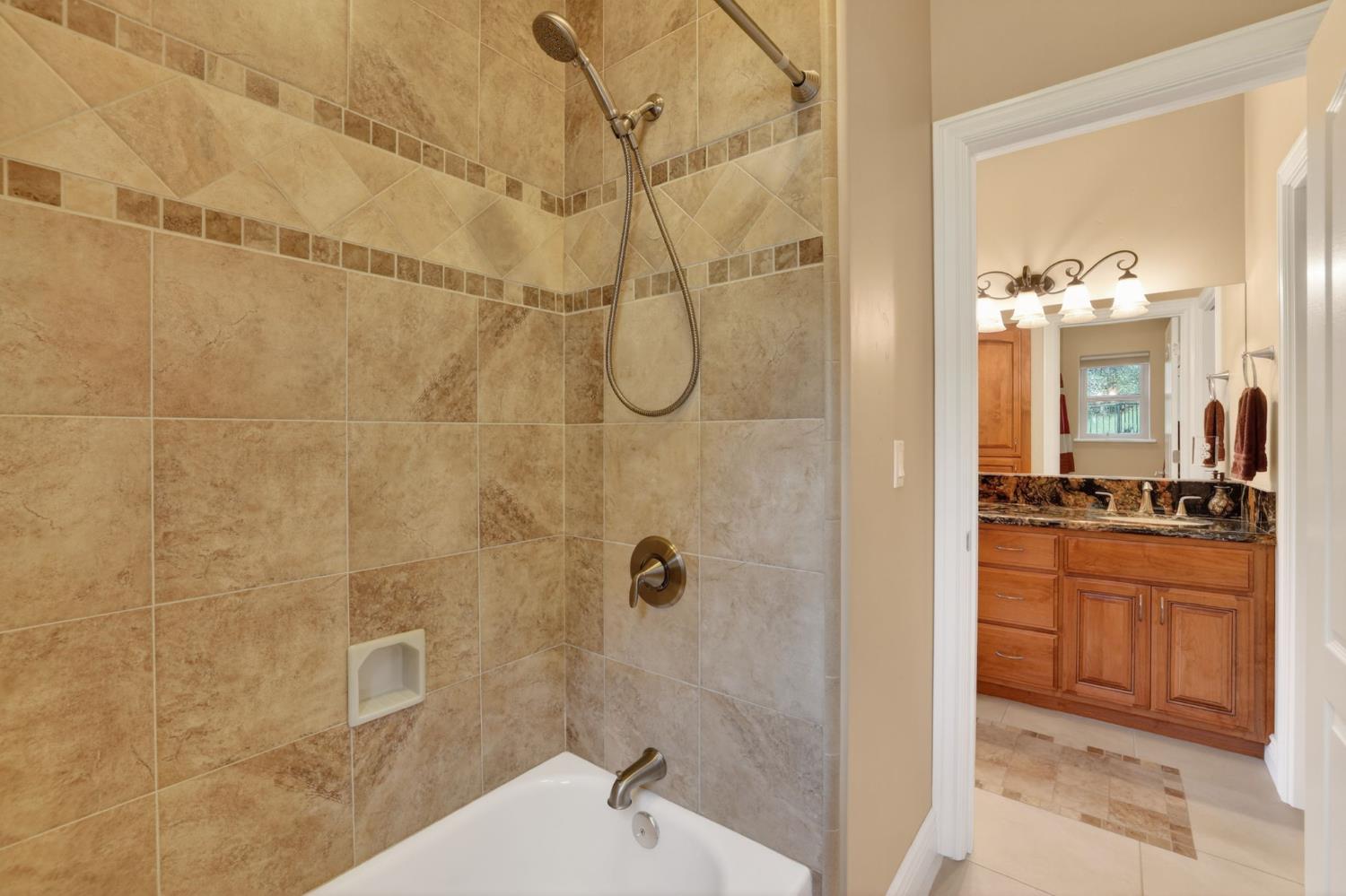 4554 Cross Creek Road Cool, CA 95614 - Photo 43 of 92 a bathroom with a granite countertop shower a sink and a mirror