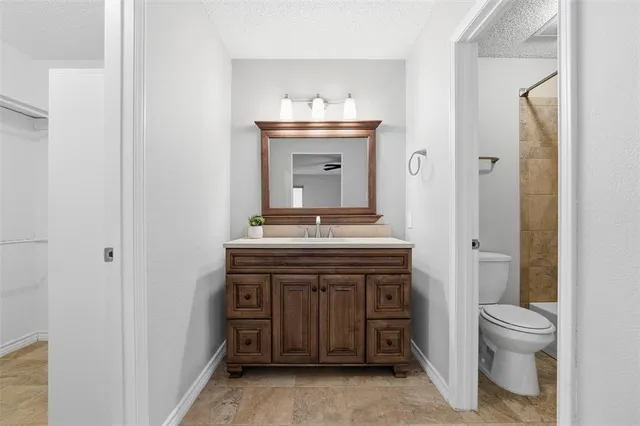 a bathroom with a sink vanity and a toilet