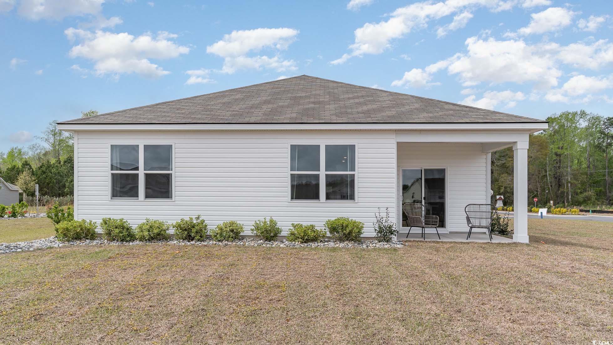 857 Farmers Passage Loop Loris, SC 29569 - Photo 23 of 25 Rear view of house with roof with shingles, a patio area, and a lawn