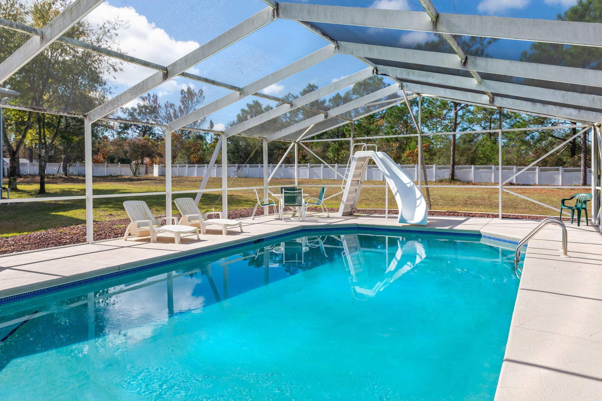 a view of a swimming pool with a patio and a yard