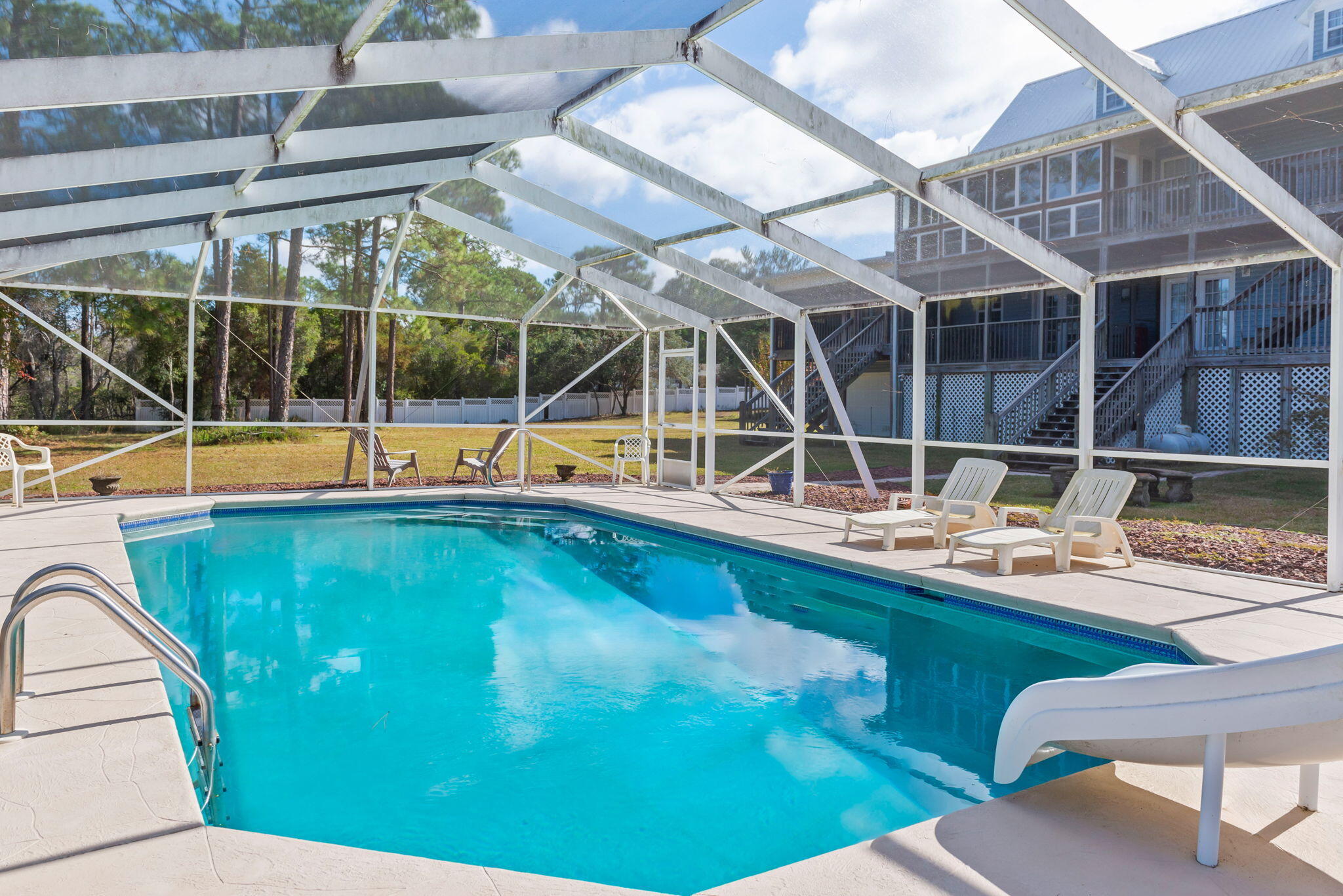 9524 Bone Bluff Drive Navarre, FL 32566 - Photo 2 of 68 a view of a swimming pool with an outdoor seating and house in the background