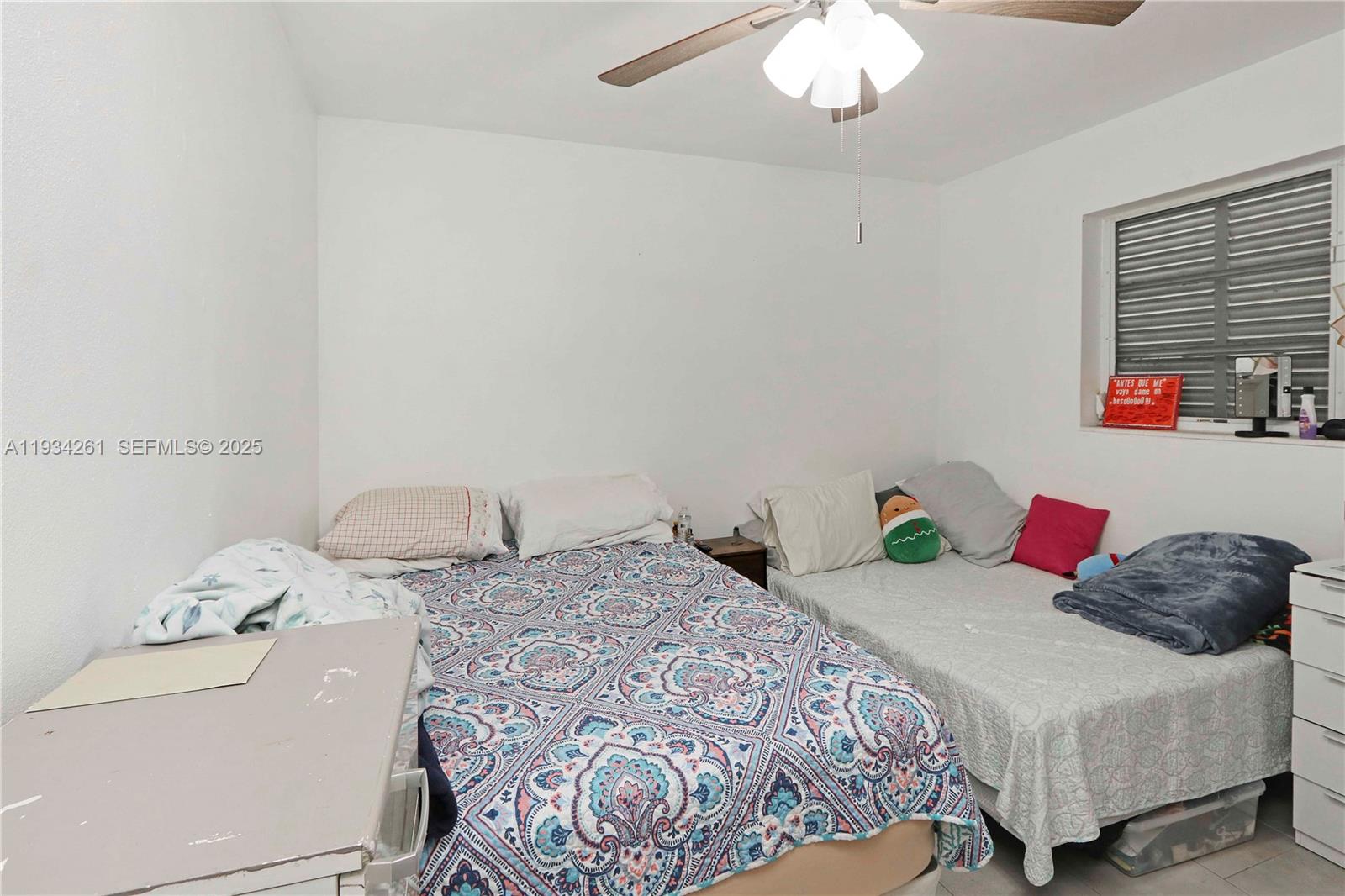 514 Northwest 21st Street Homestead, FL 33030 - Photo 17 of 45 a bedroom with a bed and a chandelier