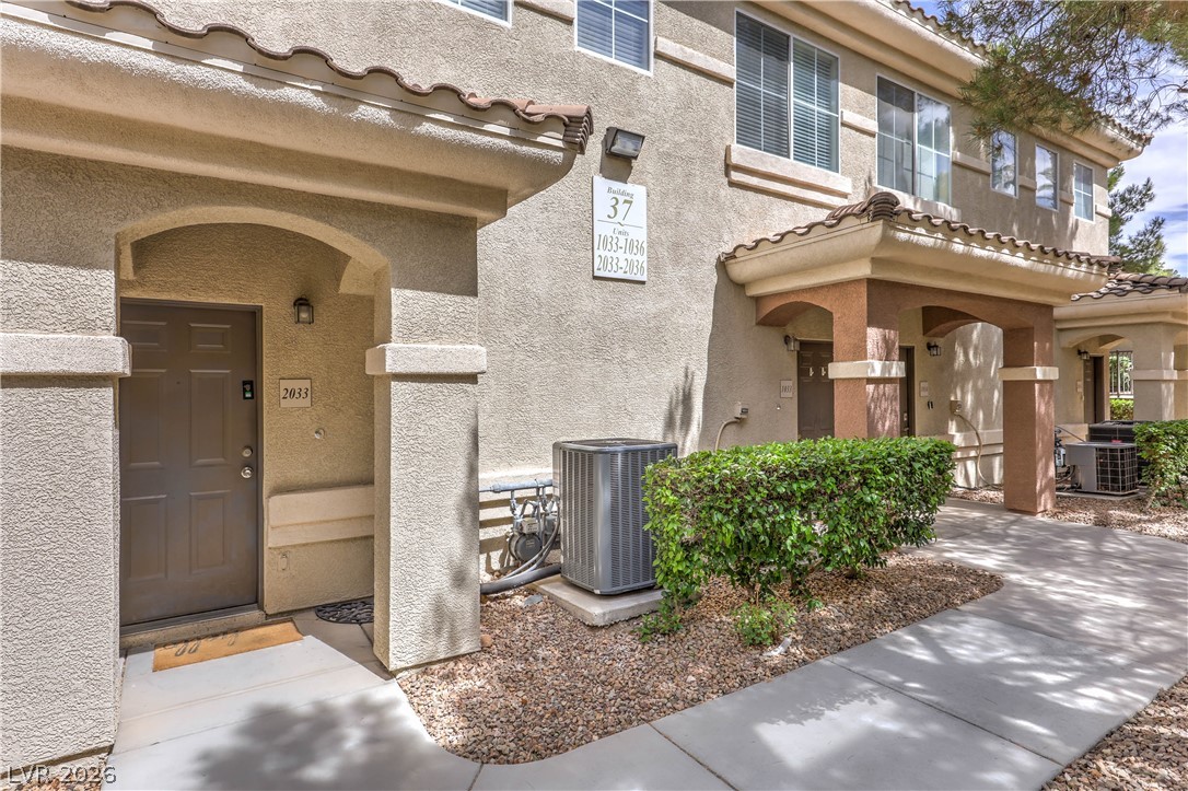 9050 West Warm Springs Road, Unit 2033 Las Vegas, NV 89148 - Photo 3 of 30 A welcoming front entrance with architectural arches and a pathway leading to the main door.