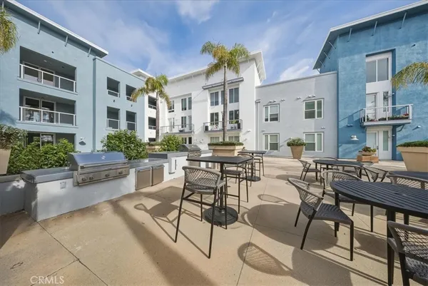 a view of a patio with couches table and chairs and potted plants