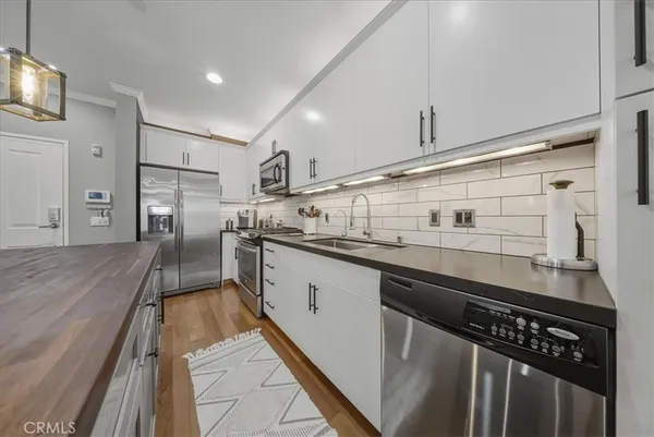 a kitchen with stainless steel appliances granite countertop a stove a sink and a refrigerator