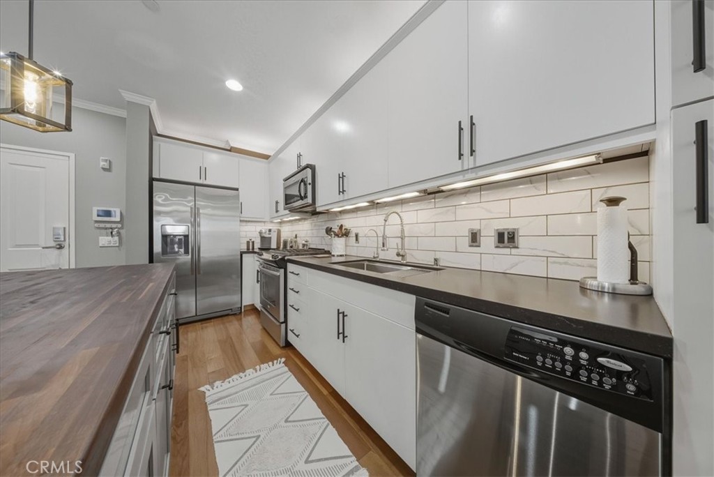 1901 Victoria Avenue, Unit 116 Oxnard, CA 93035 - Photo 3 of 31 a kitchen with stainless steel appliances a sink stove and refrigerator
