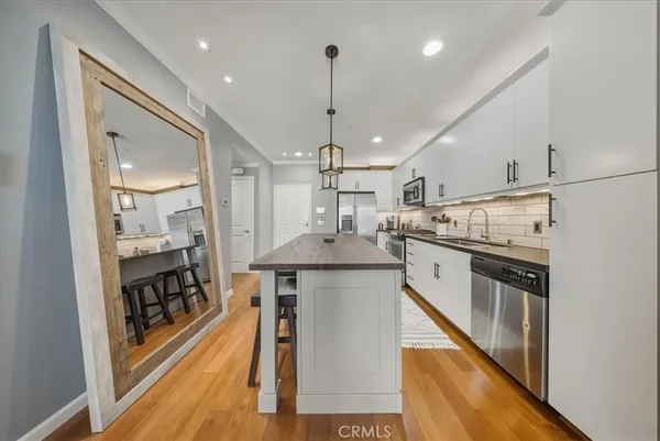 a kitchen with stainless steel appliances a sink stove and refrigerator