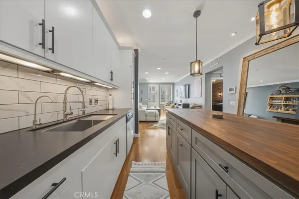 a kitchen with kitchen island a wooden floor and white cabinets