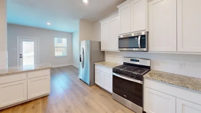 a kitchen with cabinets and steel appliances