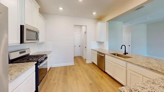 a kitchen with stainless steel appliances granite countertop a sink stove and refrigerator