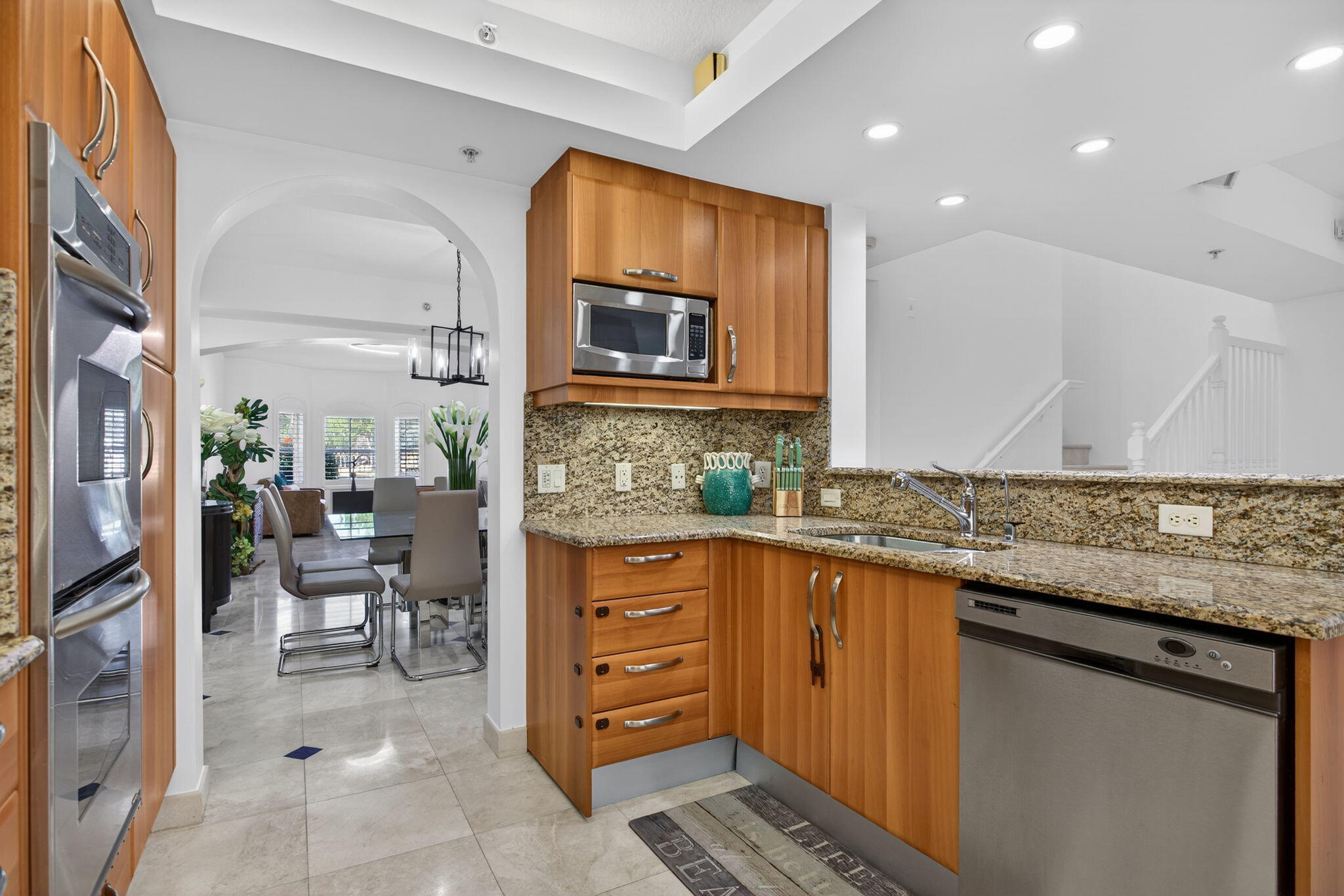 2051 Southeast 3rd Street, Unit TH8 Deerfield Beach, FL 33441 - Photo 18 of 58 a kitchen with stainless steel appliances granite countertop a stove a sink and a microwave