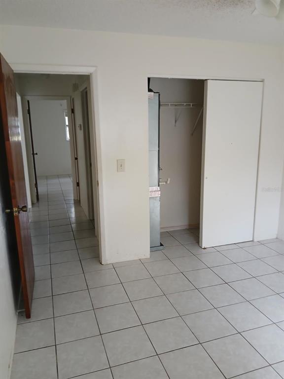 6024 Georgia Avenue New Port Richey, FL 34653 - Photo 13 of 22 a view of a refrigerator in kitchen and an empty room in wooden floor