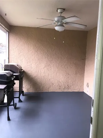 a view of a room with windows and ceiling fan