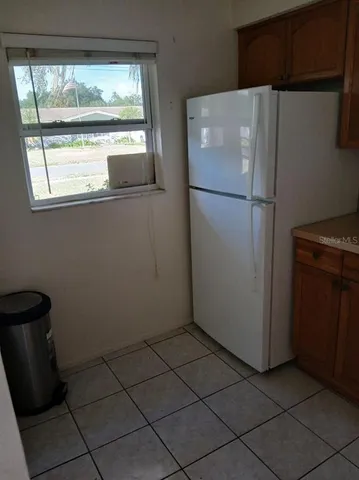a white refrigerator freezer and a stove sitting inside of a kitchen