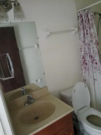 a bathroom with a sink and mirror with toilet