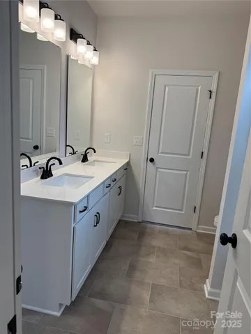 a bathroom with a double vanity sink a mirror and a