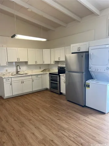 a kitchen with a refrigerator a sink and dishwasher with wooden floors