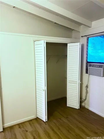 an empty room with wooden floor & windows